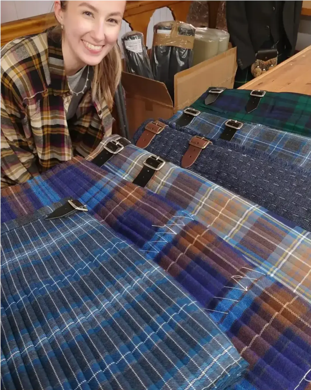 Hannah Cain Edinburgh Kiltmakers Academy graduate with a selection of kilts she made